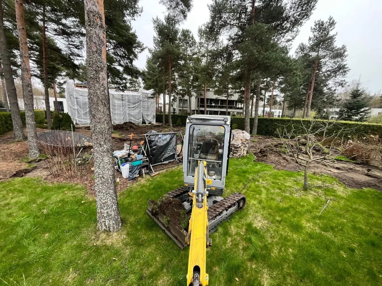 Miniekskavaator teeb aias pinnasetöid